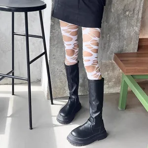 Detail shot of white distressed cut-out tights paired with black boots for a gothic punk look.