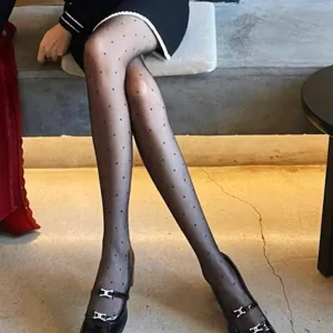 Women's ultra-sheer black tights featuring playful polka dots, perfect for spring and summer fashion looks.
