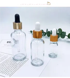 Detailed view of transparent glass dropper bottles with gold caps for essential oil storage.