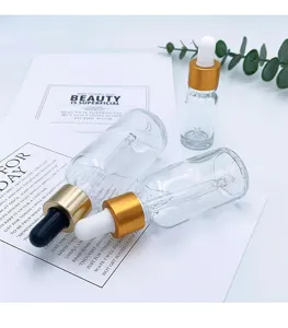 Clear glass dropper bottles set, empty cosmetic sample containers with gold caps and droppers.