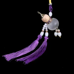 Wooden perfume gourd car hanging ornament with dual purple tassels and white beads for interior decor.