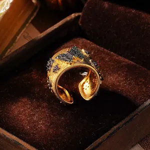 Nahaufnahme eines vergoldeten Rings mit grünem Zirkonia-Schmetterling im Samtetui