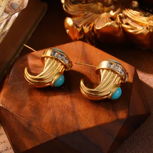 Macro-opname van vintage goudkleurige oorbellen met turquoise stenen en kristallen