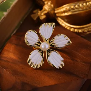 Makroaufnahme eines französischen Ohrsteckers mit weißer Emaille-Blume und Perle
