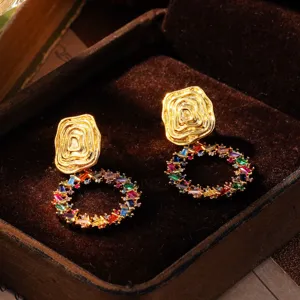 Makroansicht von goldenen Ohrringen im Vintage-Hofstil mit bunten Zirkonia-Tropfen.