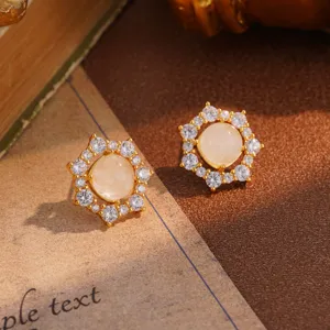 Detailed macro view of vintage flower earrings with central milky stone and crystal halo