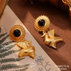 Nahaufnahme von Vintage-Gold-Schwanenohrringen mit schwarzem Emaille-Zentrum.