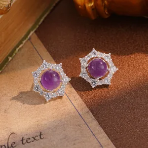 Close-up detail of vintage flower stud earrings featuring a central purple stone
