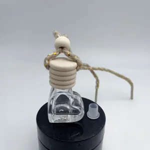 Heart shaped car perfume bottle with wooden cap and hanging rope for interior hanging decoration.