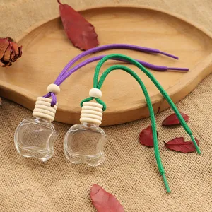 Transparent apple shaped glass car perfume bottle pendant with wooden cap and colorful ropes.