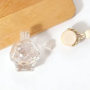 Clear rose shaped glass car perfume bottle with wooden cap and hanging rope pendant diffuser.