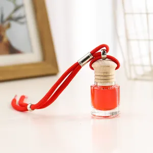 Vista detallada del frasco de perfume colgante para coche con vidrio, líquido rojo y tapón.