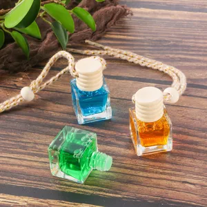 Car hanging perfume bottle detail view, featuring glass diffuser containers with wooden caps.
