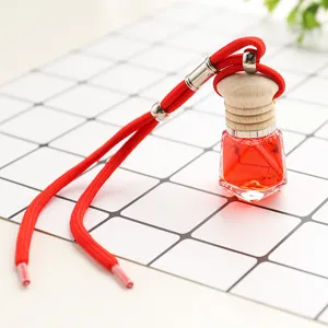 Car perfume pendant detail showing red liquid bottle with wooden cap and hanging rope.