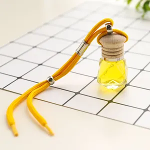 Hanging car perfume bottle with wooden cap, multifaceted glass container and yellow rope.