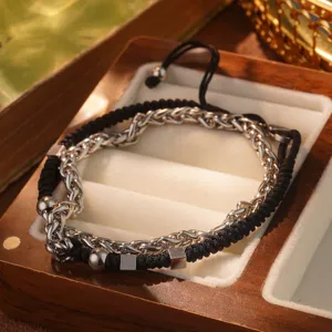 Vista macro detallada del conjunto de pulsera de cadena de acero titanio y cordón trenzado negro