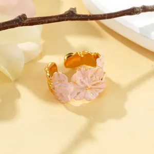 Gros plan d'une bague fleur rose texturée avec des accents dorés et design élégant