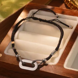 Primer plano de pulsera trenzada negra de acero de titanio con eslabones plateados