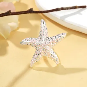 Vue rapprochée d'une bague étoile de mer en argent avec émail délicat rose clair