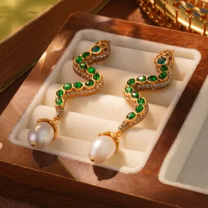 Vintage snake-shaped drop earrings with green crystals and pearls in a luxury wooden box