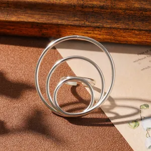 Detail view of a silver geometric ring featuring three minimalist concentric circles