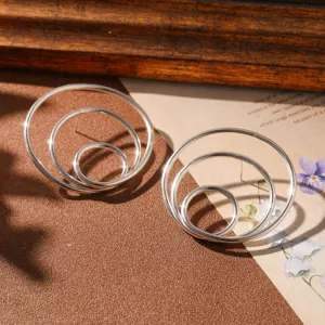 Detailed macro view of minimalist silver triple concentric circle geometric niche design earrings