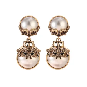 Detailed macro view of vintage French palace style gold pearl drop earrings with ornate work