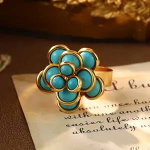 Detailed close-up of a vintage-style flower ring with turquoise beads and gold plating