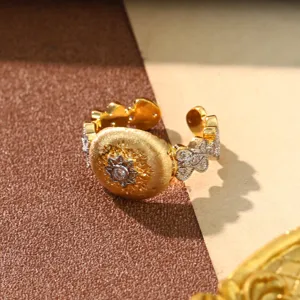 Macro detail of a vintage gold-toned ring featuring sunburst pattern and micro-inlay stones