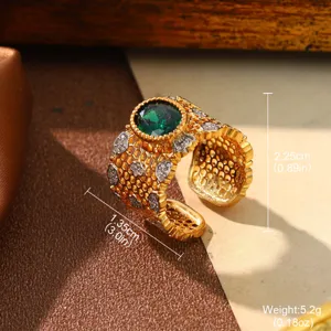 Detail of an elegant vintage palace style ring with green gemstone and gold open band.