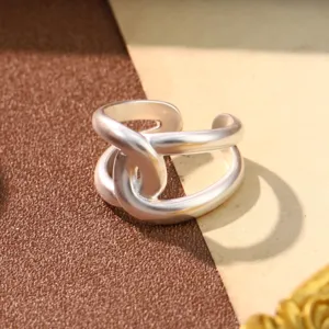 Close-up of a matte silver interlocking ring with a minimalist geometric design
