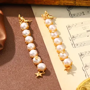 Close-up of vintage gold-tone earrings featuring a vertical row of pearls and star charm.