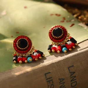 Détail de boucles d'oreilles vintage avec perles rouges et pierre noire centrale