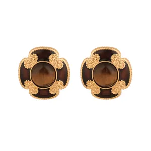Macro detail of vintage tiger eye sunflower stud earrings with gold ornate filigree