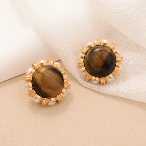 Detailed view of vintage sunflower style earrings with tiger eye stone and pearl accents