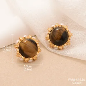 Close-up of vintage tiger eye earrings featuring sun flower design and pearl detail