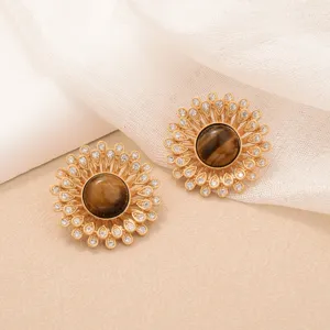 Detailed macro view of vintage sunflower earrings with tiger eye stone and crystals.