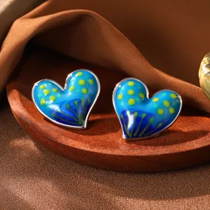 Detail von künstlerischen herzförmigen Emaille-Ohrsteckern mit blauem Ölgemäldemuster