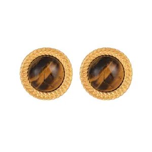 Macro view of vintage tiger eye stud earrings with wheat-ear texture gold border