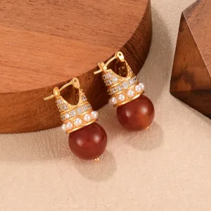 Detailed view of vintage gold crown earrings with brown tiger eye stone beads