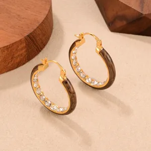 Close-up of vintage brown C-shaped hoop earrings with inlaid sparkling crystals