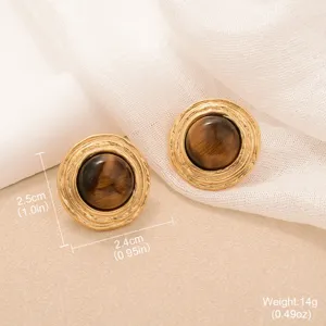 Detail view showing tiger eye stone earrings with vintage gold textured sunburst rim.