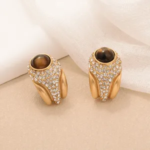 Macro detail view of retro gold tiger eye earrings with sparkling rhinestone accents