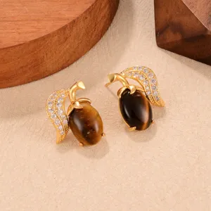 Detailansicht von Retro-Goldohrringen mit braunen Tigeraugensteinen und Kristallblatt-Akzenten.