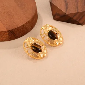 Vue détaillée de boucles d'oreilles vintage en or avec incrustation d'œil-de-tigre.