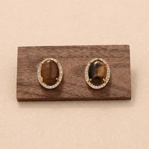 Détail macro de boucles d'oreilles rétro en pierre œil de tigre avec montures en or