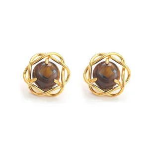 Primer plano de pendientes vintage de ojo de tigre con un detalle de marco dorado fino.