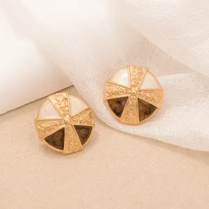Close-up of vintage gold round stud earrings with brown tiger eye and marble effect