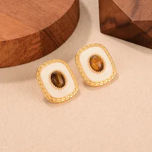 Close-up of retro French style earrings with tiger eye stone and gold metal frame.