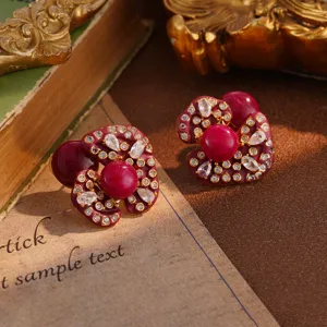 Close-up of vintage burgundy flower heart stud earrings with crystal accents